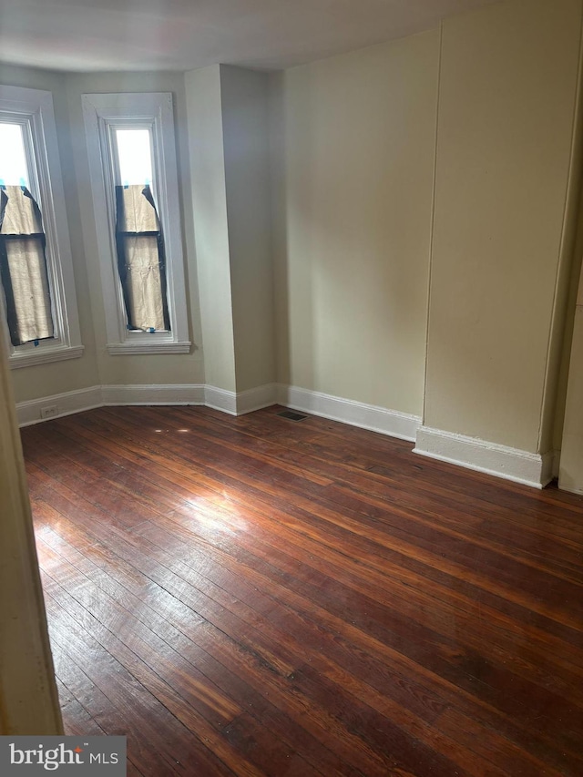 empty room with dark hardwood / wood-style flooring