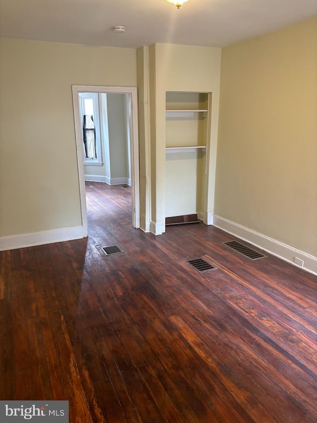 unfurnished room featuring dark wood-type flooring