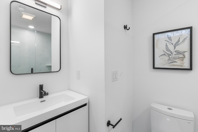 bathroom with vanity, toilet, and a shower