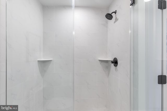 interior details featuring tiled shower