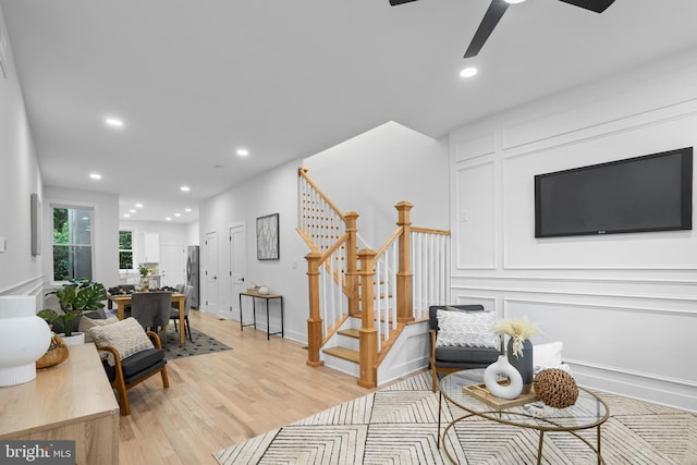 sitting room with ceiling fan and light hardwood / wood-style flooring