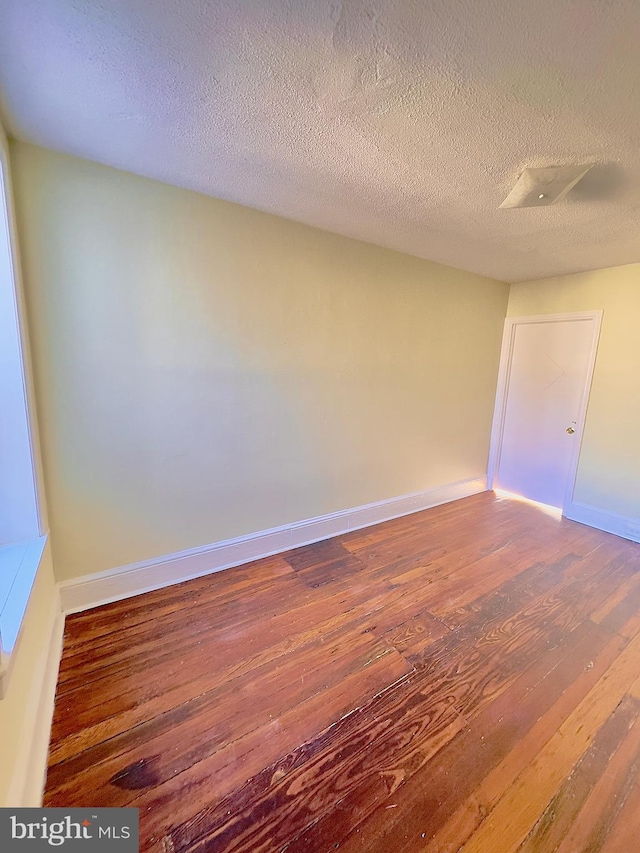 unfurnished room featuring a textured ceiling and hardwood / wood-style flooring