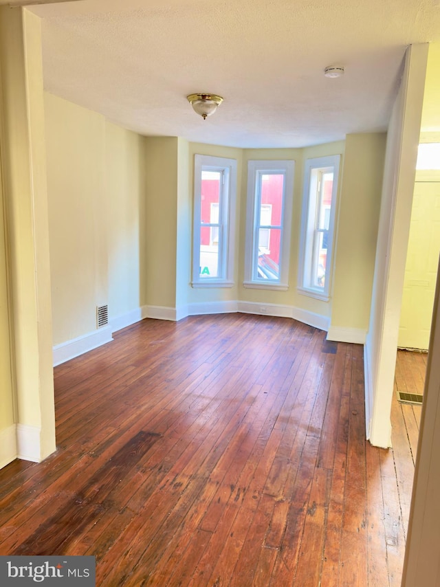 spare room featuring dark wood-type flooring