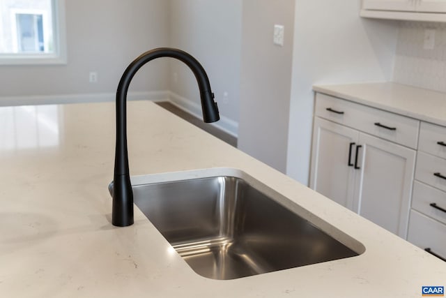 interior details with white cabinetry and sink