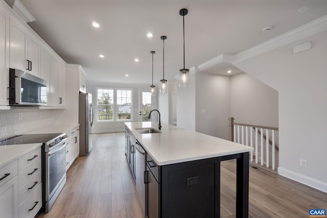 kitchen with white cabinets, sink, an island with sink, and appliances with stainless steel finishes