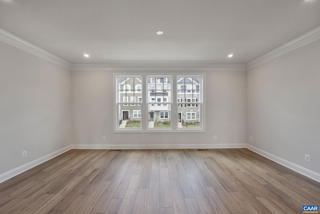 empty room featuring light hardwood / wood-style flooring and ornamental molding