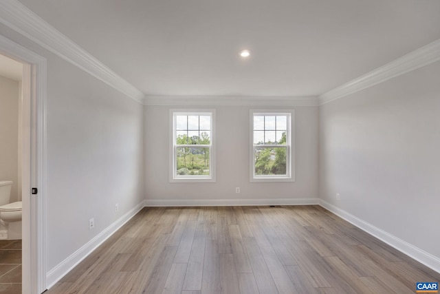 spare room featuring crown molding and light hardwood / wood-style flooring