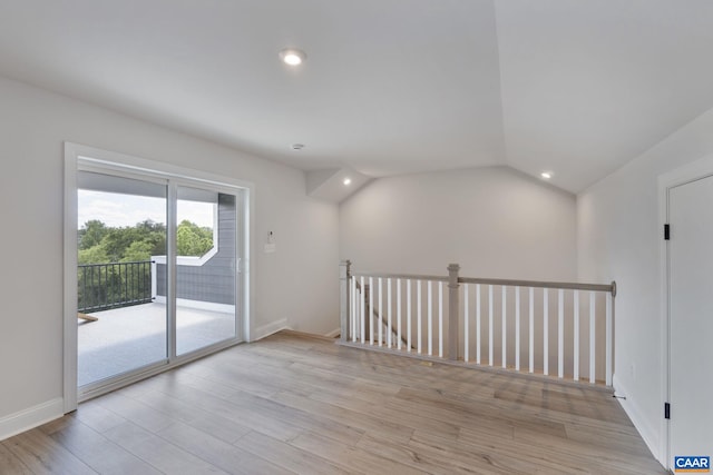 empty room with lofted ceiling and light wood-type flooring