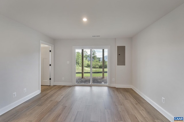 spare room with light wood-type flooring and electric panel