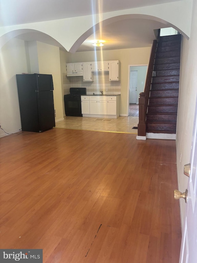 unfurnished living room with sink and light wood-type flooring