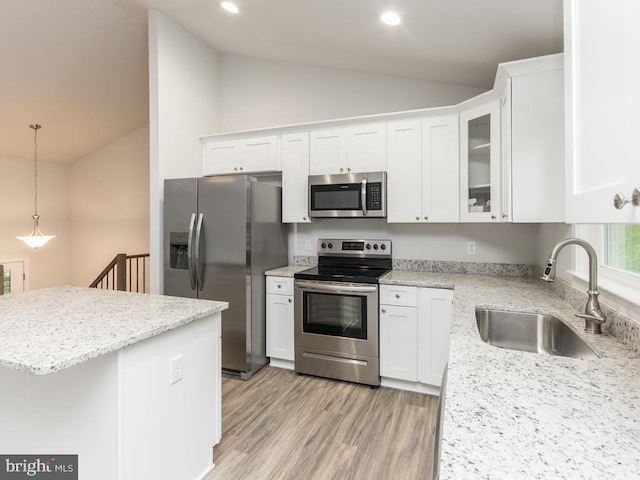 kitchen with white cabinetry, sink, stainless steel appliances, and vaulted ceiling