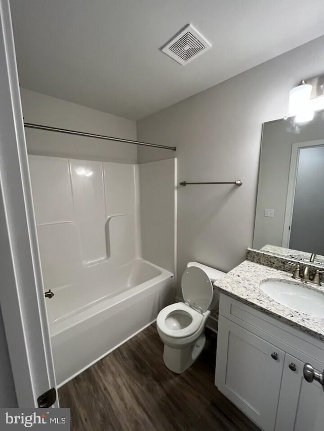 full bathroom with hardwood / wood-style flooring, vanity, toilet, and shower / washtub combination