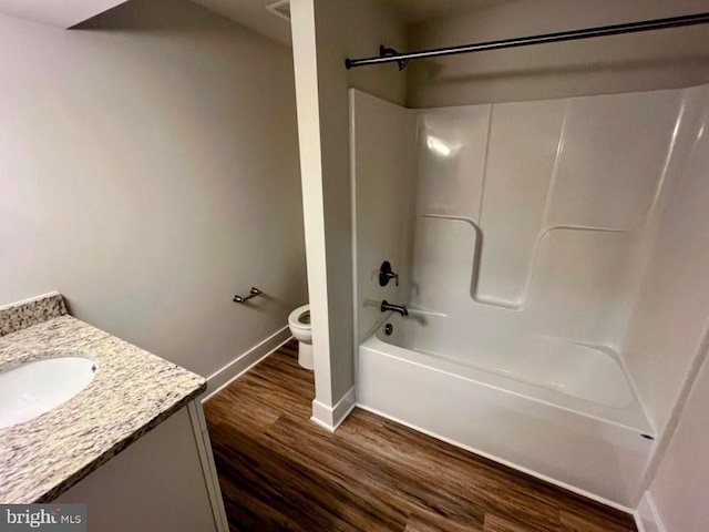 full bathroom with hardwood / wood-style floors, vanity, toilet, and shower / washtub combination