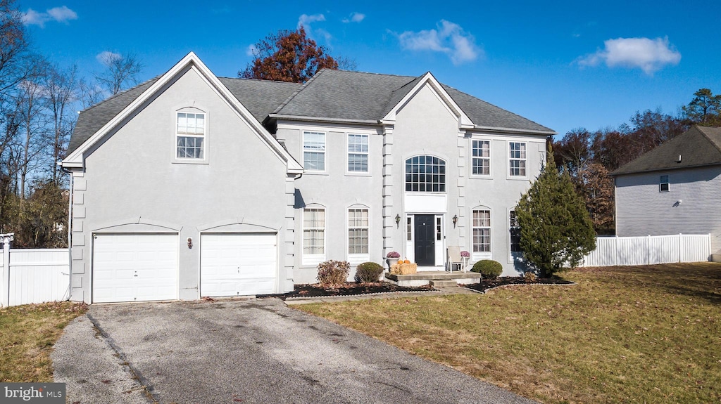 view of front of property with a garage and a front lawn