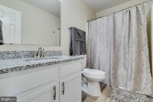 bathroom with a shower with curtain, toilet, vanity, and hardwood / wood-style flooring