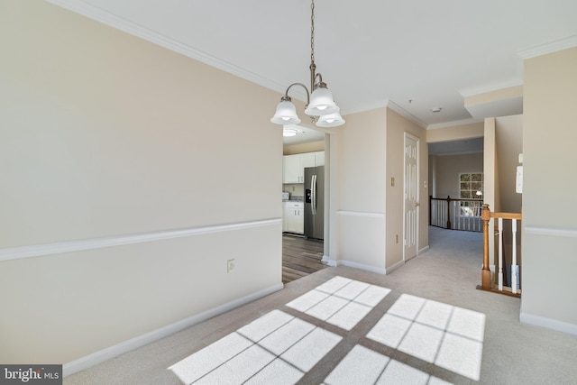 spare room featuring ornamental molding, light carpet, and a chandelier