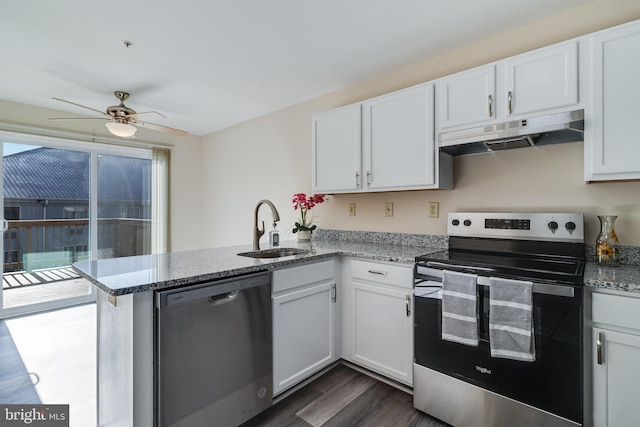 kitchen with kitchen peninsula, appliances with stainless steel finishes, dark hardwood / wood-style flooring, sink, and white cabinets