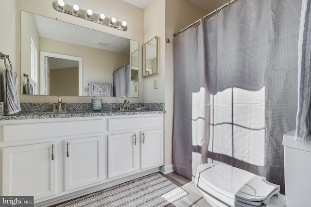 bathroom featuring hardwood / wood-style floors, vanity, and toilet