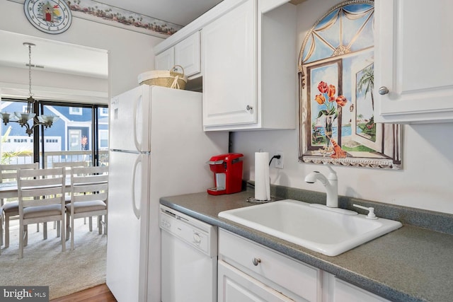 kitchen featuring dishwasher, wood-type flooring, a chandelier, and white cabinetry