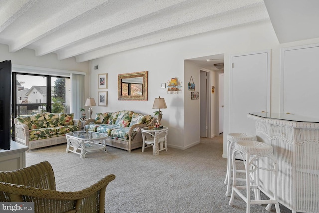 living room featuring beamed ceiling, a textured ceiling, and light colored carpet