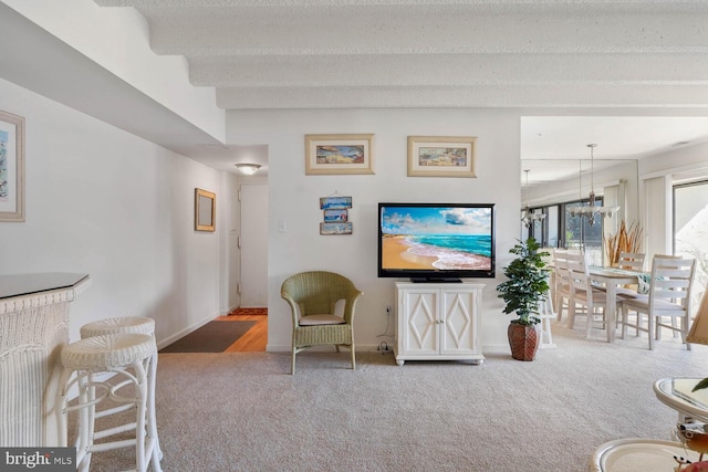 living room with a textured ceiling, carpet floors, and an inviting chandelier