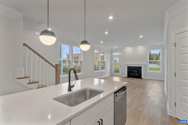 kitchen featuring a wealth of natural light, sink, light hardwood / wood-style floors, decorative light fixtures, and white cabinets