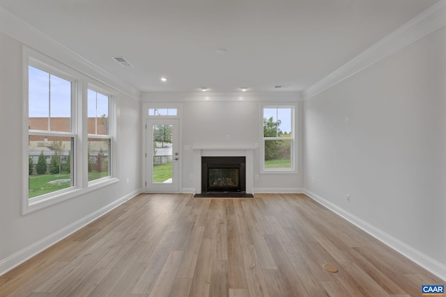 unfurnished living room with crown molding and light hardwood / wood-style flooring