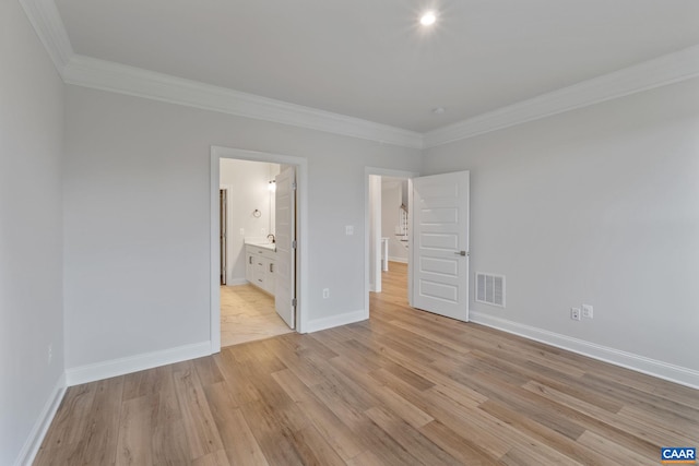 unfurnished bedroom featuring ensuite bath, crown molding, and light hardwood / wood-style floors