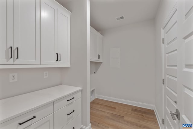 clothes washing area featuring light hardwood / wood-style flooring