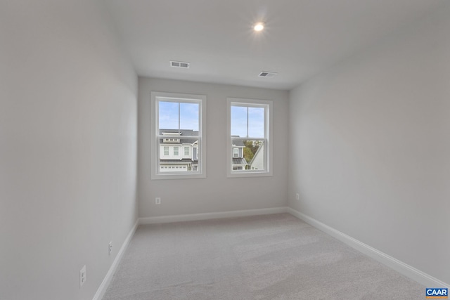 unfurnished room featuring light carpet