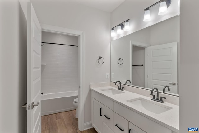 full bathroom with vanity, wood-type flooring, shower / bathtub combination, and toilet