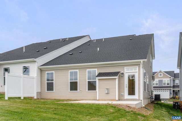 back of house featuring central air condition unit and a yard