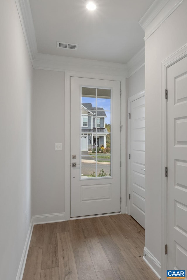 entryway with light wood-type flooring and crown molding