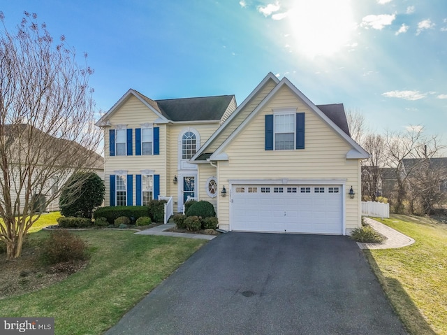 traditional-style house with a front lawn, an attached garage, and driveway