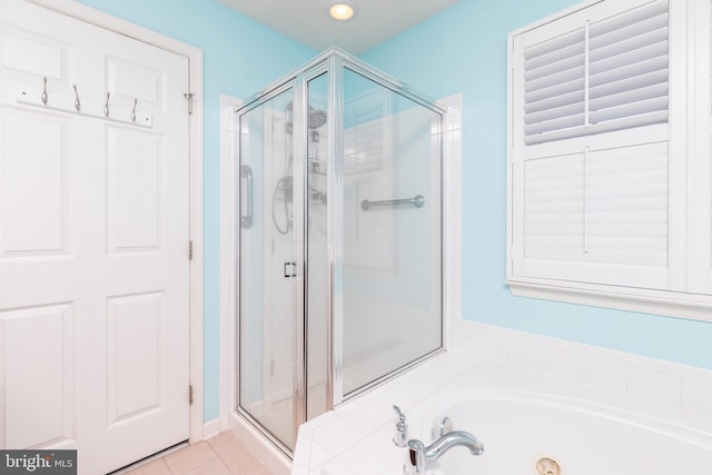 bathroom featuring tile patterned flooring, a garden tub, and a stall shower