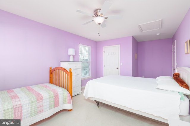 bedroom with light colored carpet, attic access, and ceiling fan