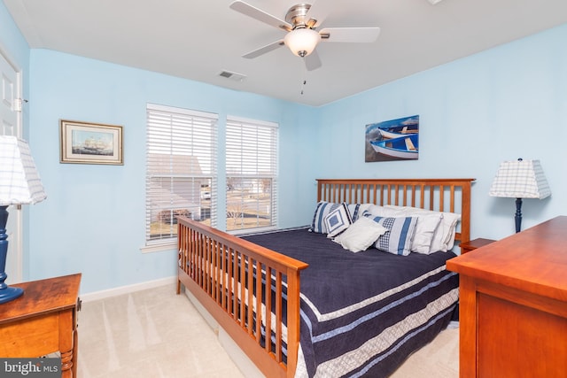 bedroom featuring a ceiling fan, baseboards, visible vents, and light carpet