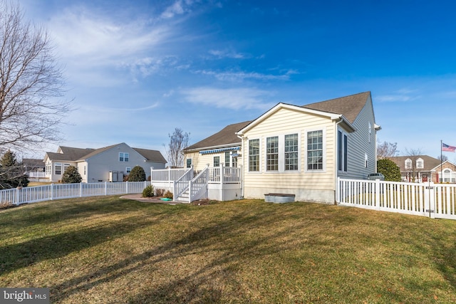 rear view of property with a lawn and a fenced backyard