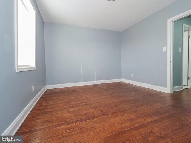 empty room with dark hardwood / wood-style flooring