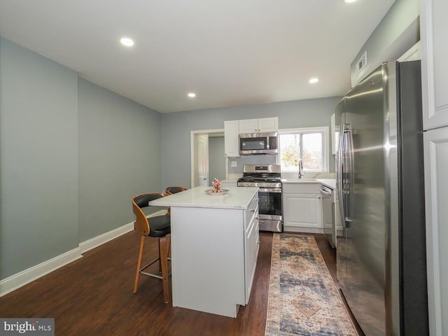 kitchen featuring dark hardwood / wood-style floors, a kitchen island, white cabinetry, and stainless steel appliances