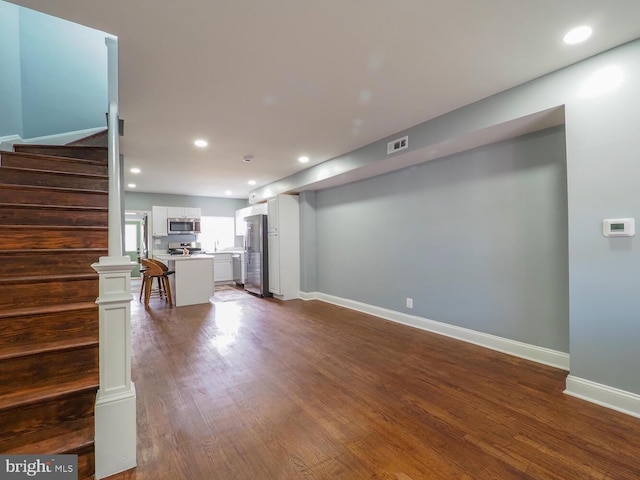 unfurnished living room with dark wood-type flooring