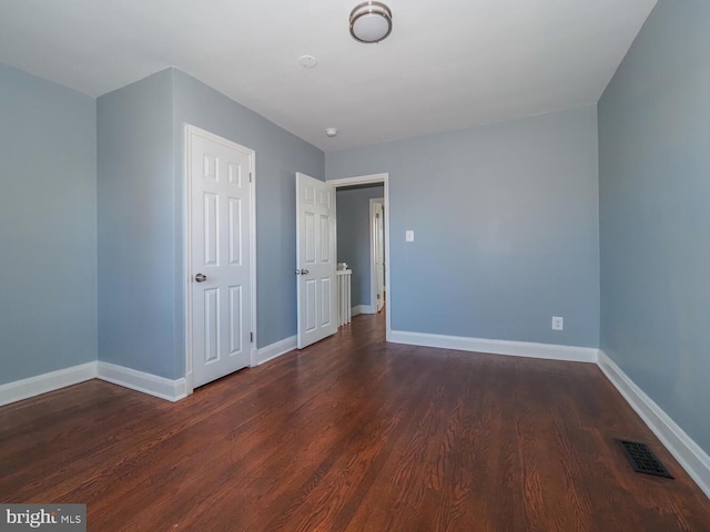 unfurnished bedroom with dark wood-type flooring