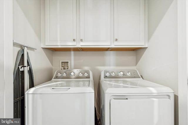 clothes washing area featuring washer and dryer and cabinets