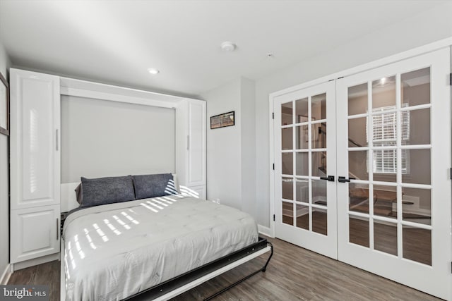 bedroom with french doors and hardwood / wood-style floors