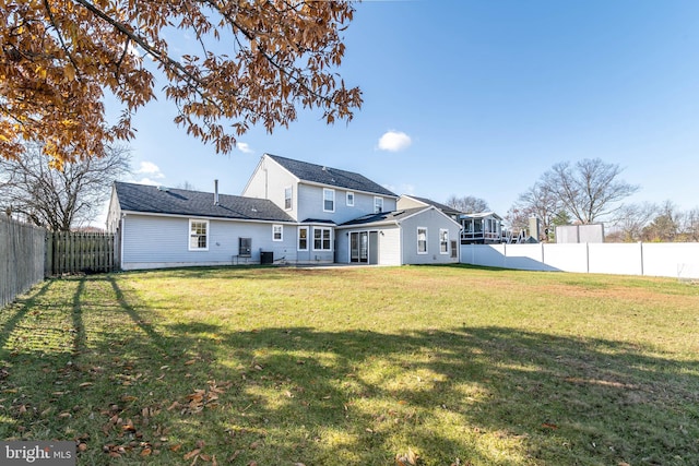 back of property with a lawn and a patio