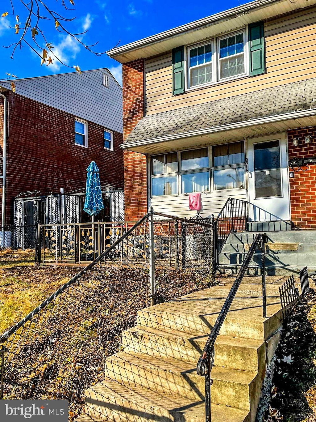 view of front facade with fence and brick siding