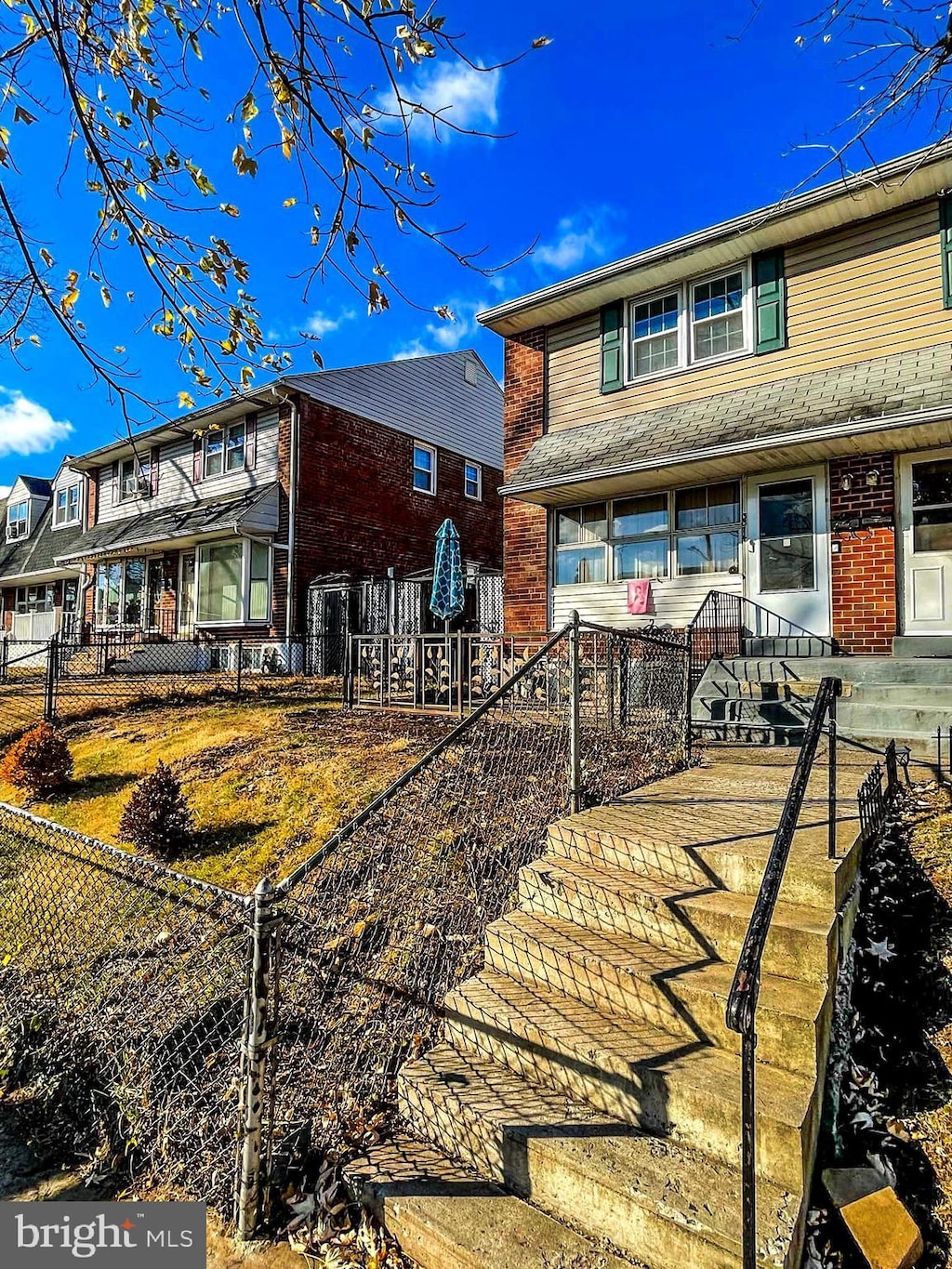 rear view of property featuring a fenced front yard and brick siding