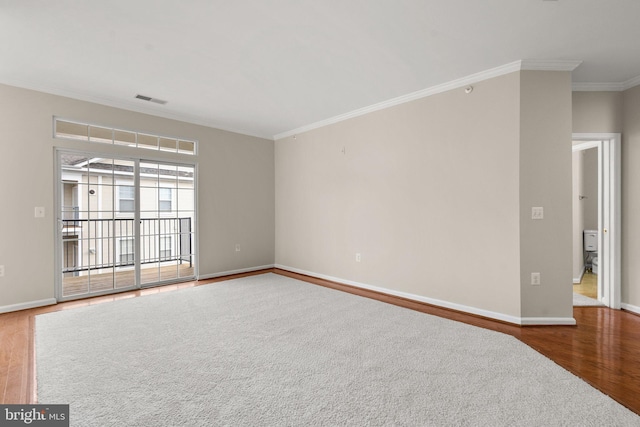 unfurnished room with ornamental molding, visible vents, baseboards, and wood finished floors