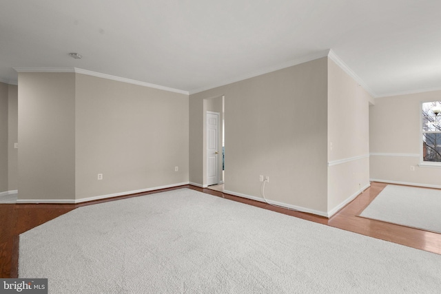 empty room with crown molding, baseboards, and wood finished floors