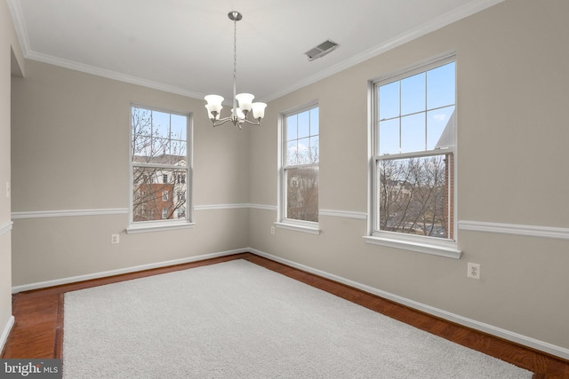 unfurnished room with a chandelier, visible vents, baseboards, and wood finished floors